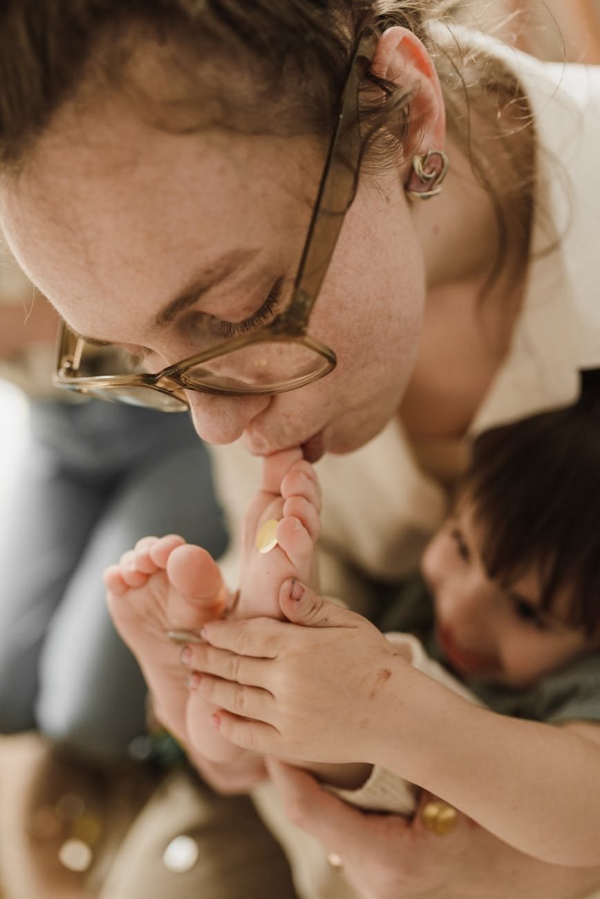 a mother kissing her son s foot